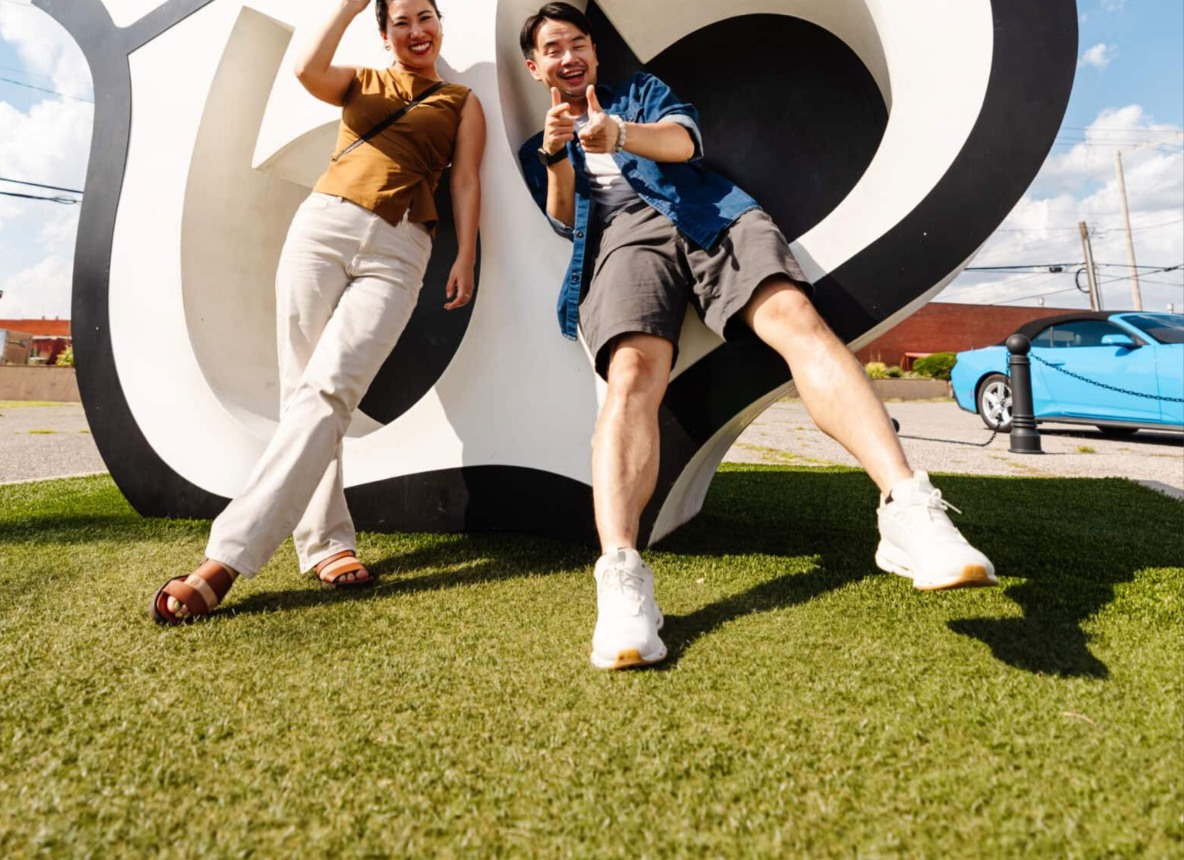 Travelers posing at a Route 66 roadside landmark